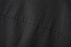 Macro detail of black striped poplin fabric with professional industrial stitching texture
