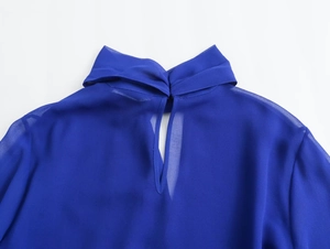 Detail of royal blue chiffon blouse collar with elegant teardrop cutout and textured fabric