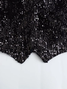 Detailed view of 2023 black sequin vest showing premium shimmering texture and wavy hemline