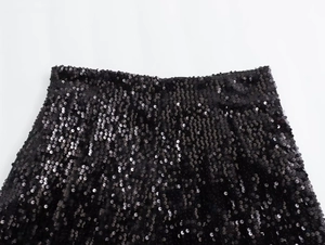 Dettaglio macro della vita alta con ricami di paillettes nere dense su pantaloncini Y2K