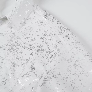 Macro shot of white shirt fabric with silver metallic foil print and collar size label