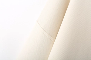 Detail of premium cream ribbed fabric showing high-quality stitching on white sweatshirt