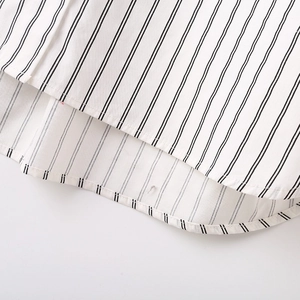 Close-up of women's Y2K striped shirt featuring a curved hem and fine stitching detail