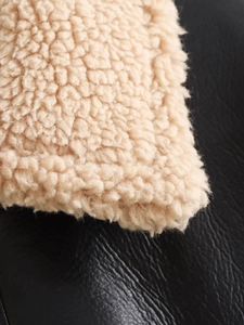 Détail de couture en faux sherpa et cuir noir grainé sur le gilet pour femme