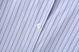 Gros plan détaillé des rayures bleues verticales et des boutons blancs sur une chemise