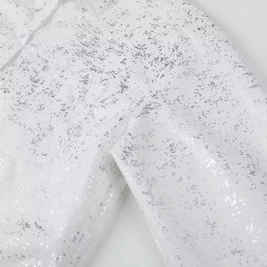 Close-up of Y2K white shirt featuring metallic silver foil print and pocket detail