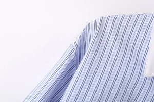 Gros plan détaillé des coutures d'épaule et du col blanc de la chemise rayée bleue et blanche