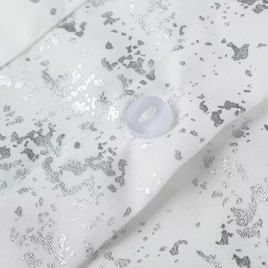 Detail of white shirt collar with silver metallic print and a translucent button