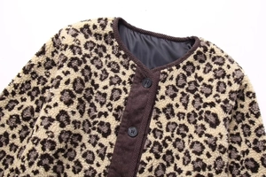 Detail of leopard print fleece jacket showing corduroy trim and black button closure