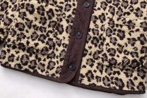Close-up of leopard print fleece jacket showing corduroy trim and black buttons detail