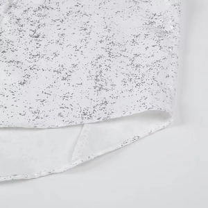 Detailed view of white fabric with silver foil print and high-quality hem stitching