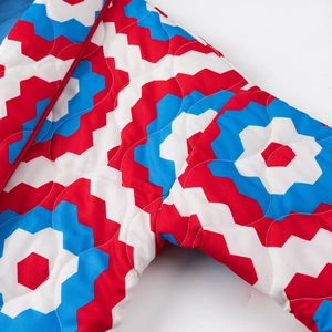 Detailed macro view of red, blue, and white geometric ripple quilted fabric patterns