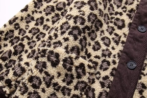 Detail of leopard print faux shearling fabric with brown corduroy button placket