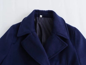 Detailed view of dark blue wool coat lapels with smooth lining and premium texture