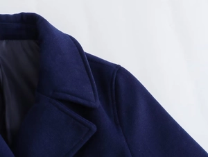 Detail of navy blue wool coat notched lapel with precise stitching and premium texture