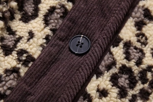 Detail of leopard print fleece fabric with corduroy trim and marble button texture