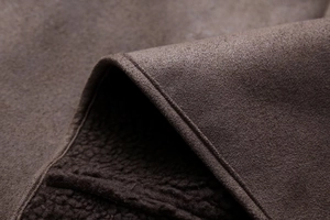 Detail shot of brown suede jacket with warm fleece lining and premium texture