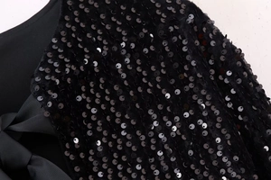 Detail of shimmering black sequins and textured grosgrain ribbon bow on the Y2K top