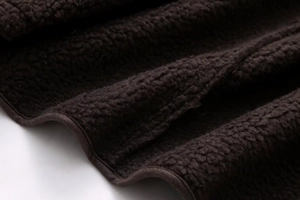Close-up of deep brown Sherpa fleece fabric showing soft texture and premium binding