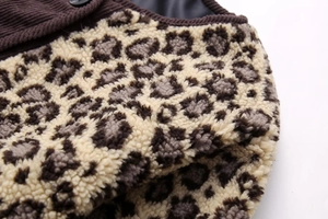 Macro view of leopard print faux fur texture and brown corduroy fabric stitching detail
