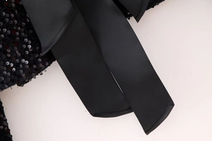 Detailed macro view of black sequins and a premium textured ribbed satin ribbon tie