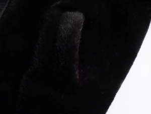 Macro view of dense black faux fur texture on a stylish Y2K pilot bomber jacket