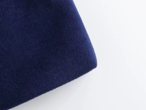 Macro shot of dark blue fabric texture and soft wool finish for the short lapel coat