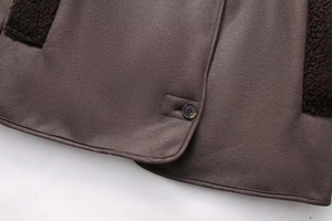 Detail of suede jacket hem with plush shearling lining and premium marble button