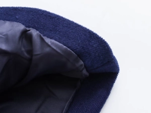 Detailed macro view of dark blue wool beret fabric texture and smooth inner lining