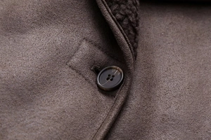 Macro detail of faux suede jacket with warm shearling lining and premium tortoise button