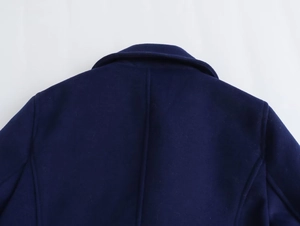 Detailed close-up of stitching and wool texture on back collar of navy blue coat