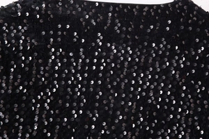 Detailed macro view of black sequins on luxury velvet fabric with neat edge stitching