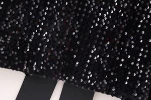 Close-up of black sequins on Y2K style slim fit top showing high metallic shine
