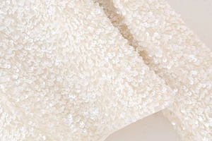 Vue macro de paillettes blanches scintillantes et texture fine sur un haut Y2K