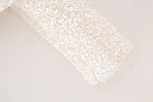 Détail rapproché des paillettes blanches sur le haut Y2K à manches longues et coupe ajustée