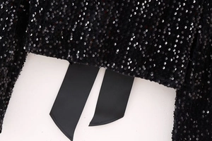 Detail of shimmering black sequins and grosgrain ribbons on a Y2K style party blouse
