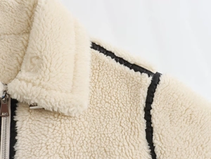 Détail de la veste en polaire avec liseré en similicuir noir et fermeture éclair en métal