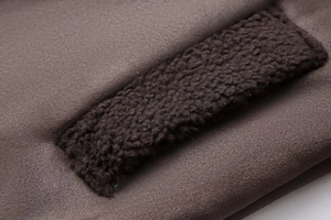 Close-up of deep brown suede jacket with warm coffee-colored faux shearling trim details