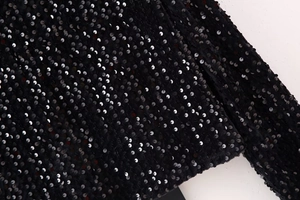 Close-up detail of shimmering black sequins on Y2K style slim fit bow-tie shirt