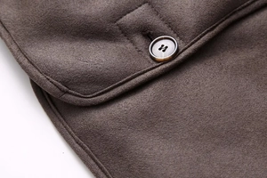 Macro shot of dark brown suede jacket detailing premium stitching and resin button