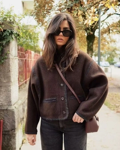Detail of dark brown wool blend jacket featuring single-breasted buttons and silhouette cut