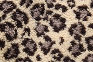 Detailed close-up of soft faux fur leopard print fabric with high fiber density and texture