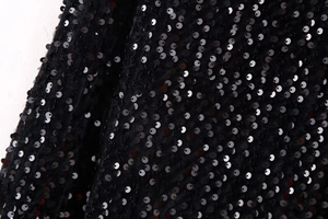 Macro shot of black sequins on slim-fit Y2K top showing shimmering texture details
