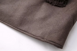 Detail view of the hem stitching and texture on a brown Y2K faux suede jacket
