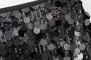 Gros plan sur le tissu à paillettes noires superposées sur résille pour mini jupe