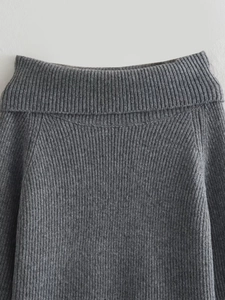 Detail view of the dark grey vertical ribbed knit texture and wide fold-over neckline