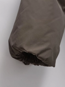 Detail shot of dark brown winter jacket featuring windproof twill fabric and elastic cuffs
