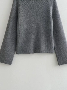 Detailed close-up of grey vertical ribbed knit sweater showing premium wool texture