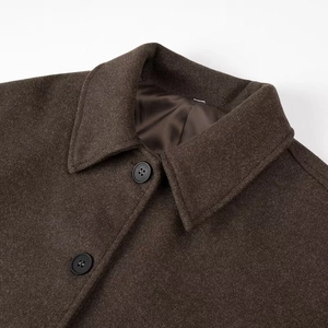 Macro detail of dark brown wool coat lapel with premium two-button closure
