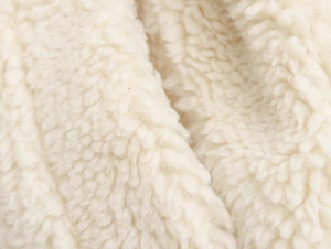 Vue macro de la texture polaire sherpa blanche montrant les détails de la fourrure